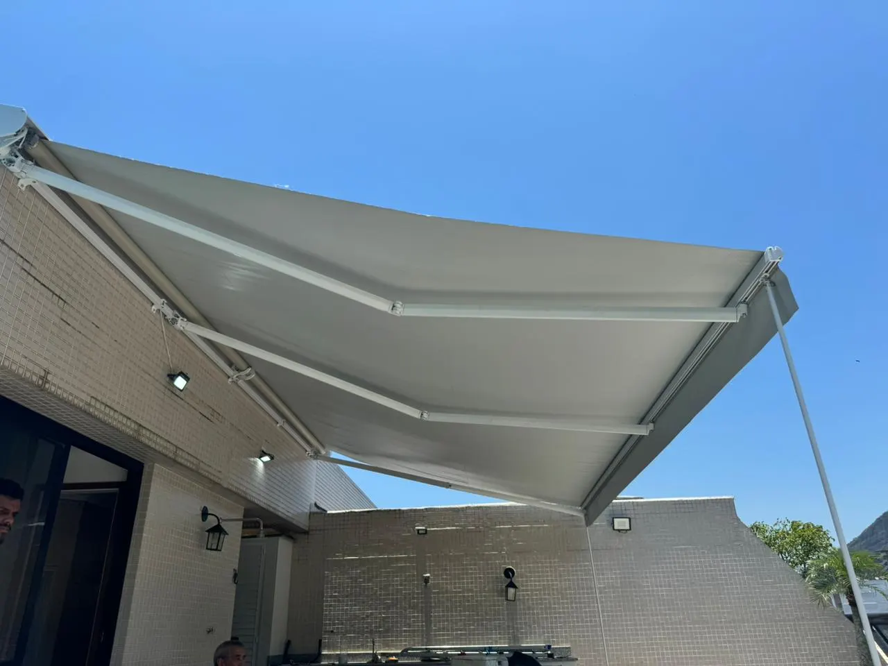 Toldo articulado e motorizado em lona instalado em área externa